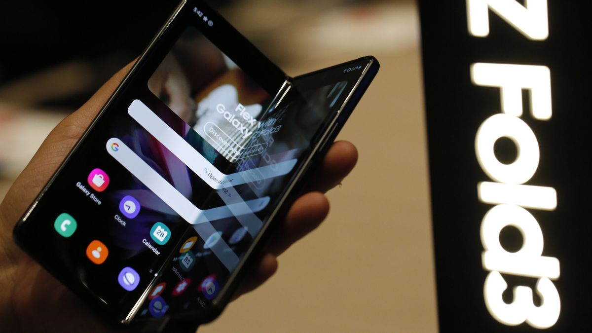 An attendee handles a Galaxy Z Fold3 smartphone on the Samsung Electronics Co. stand on the opening day of the MWC Barcelona at the Fira de Barcelona venue in Barcelona, Spain, on Monday, Feb. 28, 2022. Over 1,800 exhibitors and attendees from 183 countries will attend the annual event, which runs from Feb. 28 to March 3. Photographer: Angel Garcia/Bloomberg via Getty Images