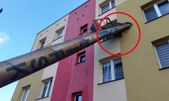 Stalowy komin złamany w pół. Wbił się w okno mieszkania w bloku