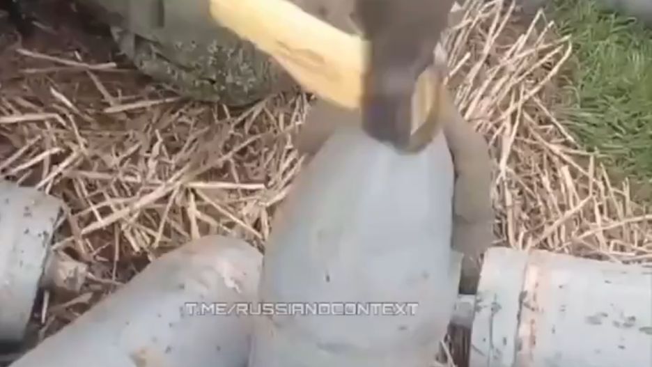 Rosjanin przygotowujący pociski kal. 152 mm za pomocą siekiery. 