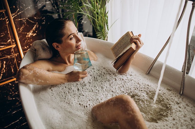 Kobieta czytająca książkę w wannie - zdjęcie.
