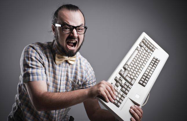 Zdjęcie faceta wkurzonego na komputer pochodzi z serwisu Shutterstock