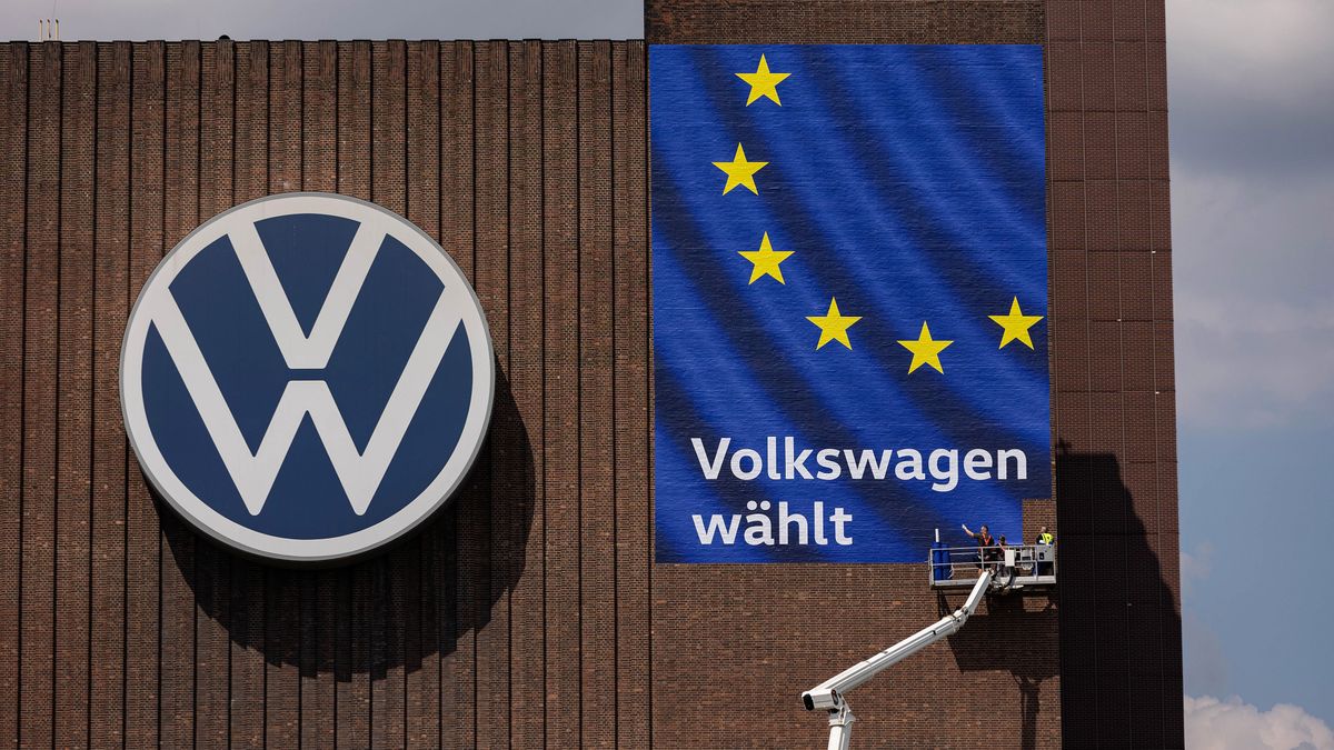 Workers install a European Union election campaign poster on a building at the Volkswagen AG factory in Wolfsburg, Germany, on Thursday, May 23, 2024. Auto sales in Europe rose 12% in April as manufacturers including Volkswagen AG and Renault SA benefited from robust demand for plug-in and conventional cars in several major markets. Photographer: Krisztian Bocsi/Bloomberg via Getty Images