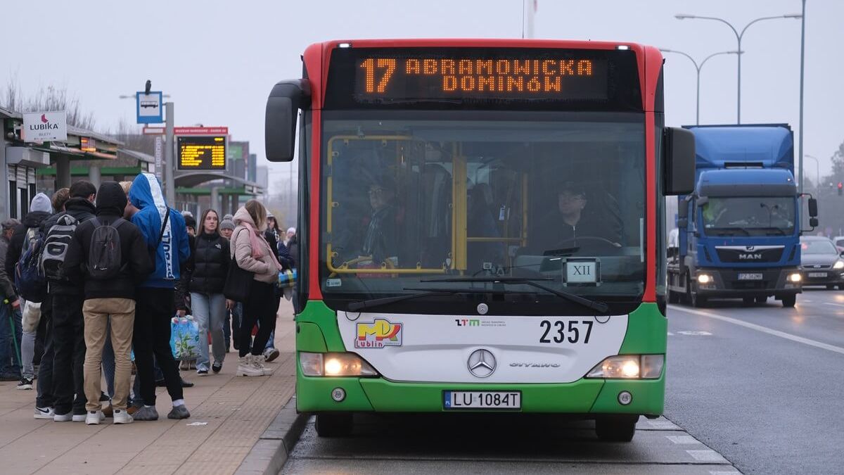Pasażerowie wsiadający do autobusu na przystanku