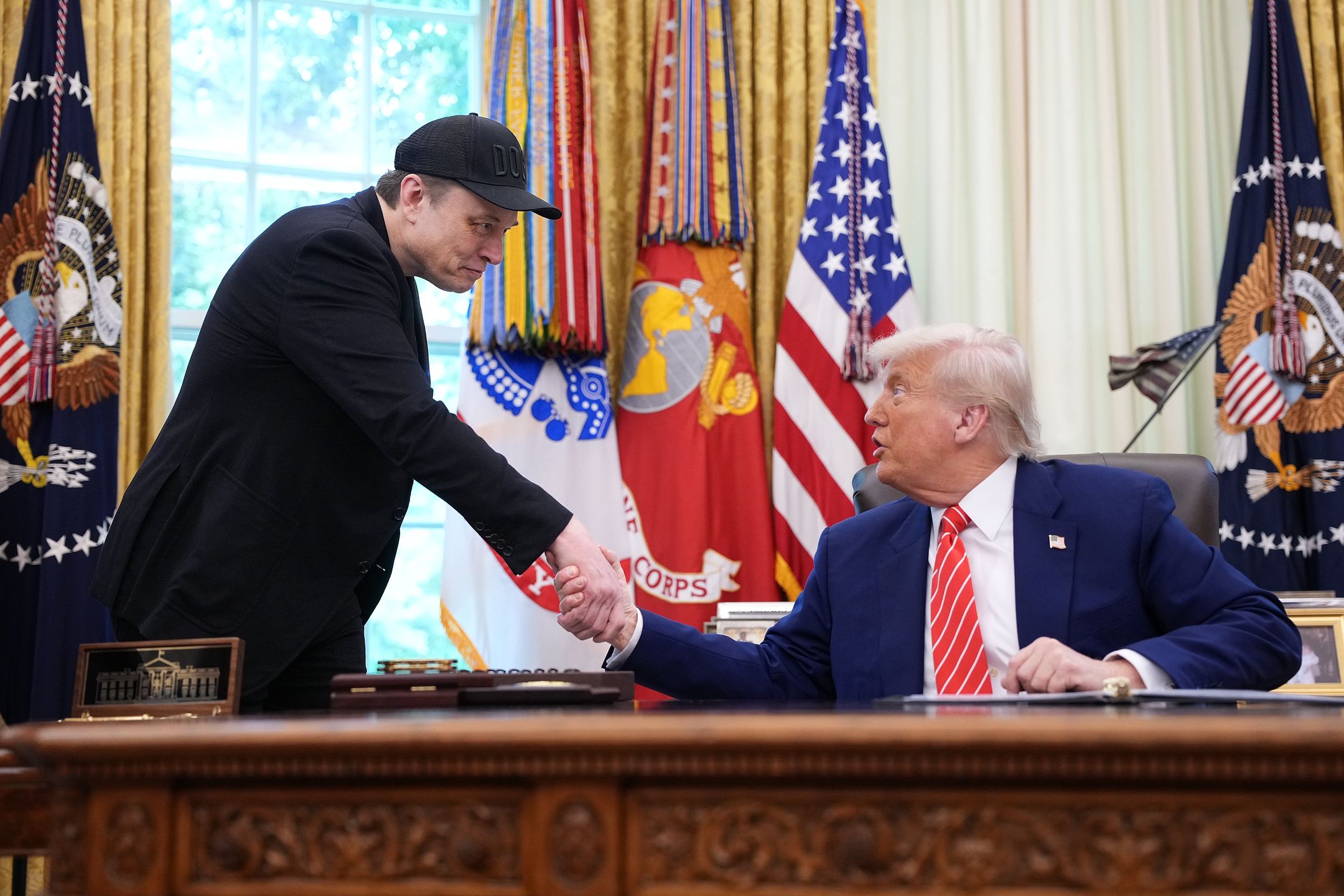 WASHINGTON, DC - MAY 30: Tesla CEO Elon Musk shakes hands with U.S. President Donald Trump as they speak to reporters in the Oval Office of the White House on May 30, 2025 in Washington, DC. Musk, who served as an adviser to Trump and led the Department of Government Efficiency, announced he would leave his role in the Trump administration to refocus on his businesses.  (Photo by Kevin Dietsch/Getty Images)
