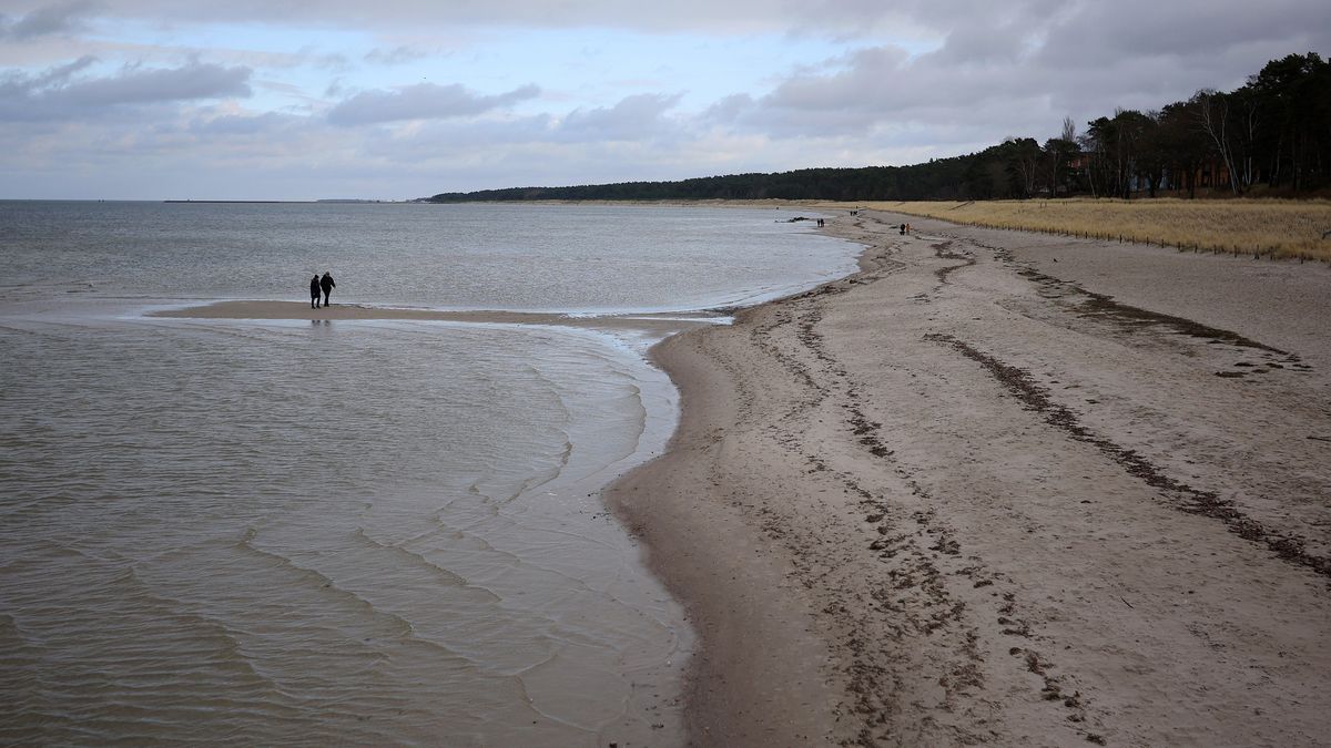 Visitors on a beach on the Baltic Sea in Lubmin, Germany, on Saturday, Jan. 14, 2023. At Lubmin, the Neptune LNG floating storage regasification unit (FSRU) will pump at least 4.5 billion cubic meters of gas per year into the German grid, equal to about 8% of the transport capacity of the key Russian Nord Stream pipeline that was put out of operation following blasts in September. Photographer: Krisztian Bocsi/Bloomberg via Getty Images