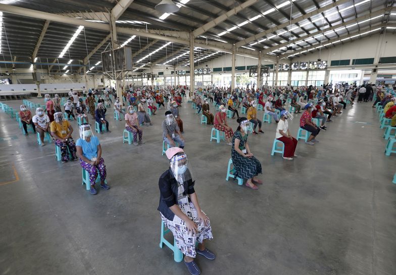 Pracownicy z fabryki butów w Azji czekają na badanie lekarskie.