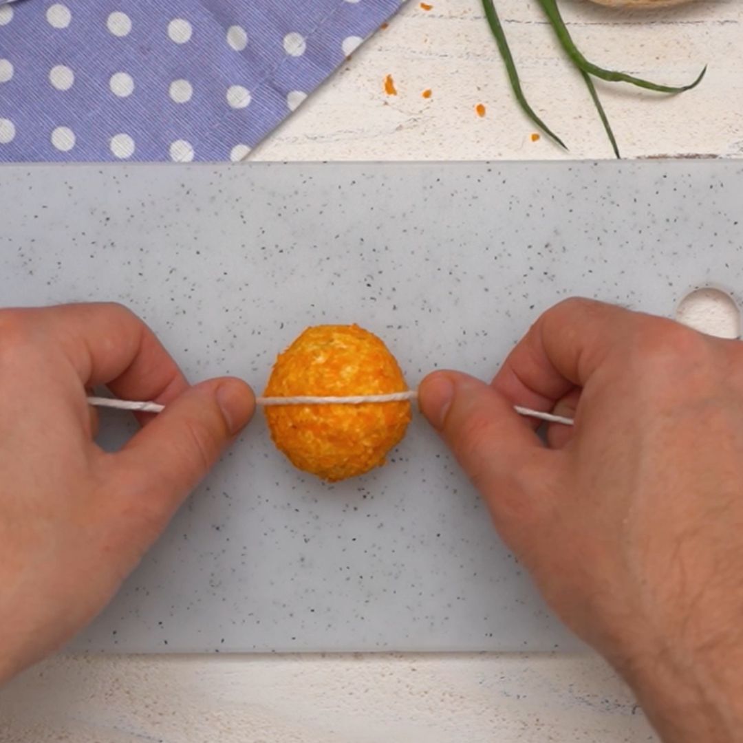 Using a piece of string, you can give the cheese balls a pumpkin shape.