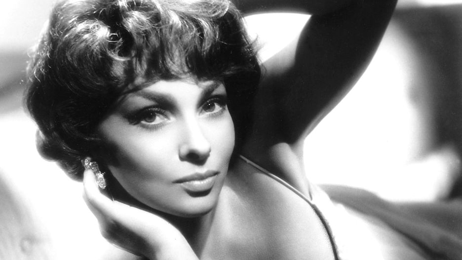 Gina LollobrigidaGina Lollobrigida, Italian actress, wearing a low-cut thin strap white top in a studio portrait, with her hands up to her head, circa 1950. (Photo by Silver Screen Collection/Getty Images)Silver Screen CollectionBlack and White, Huty18122, one person, studio shot