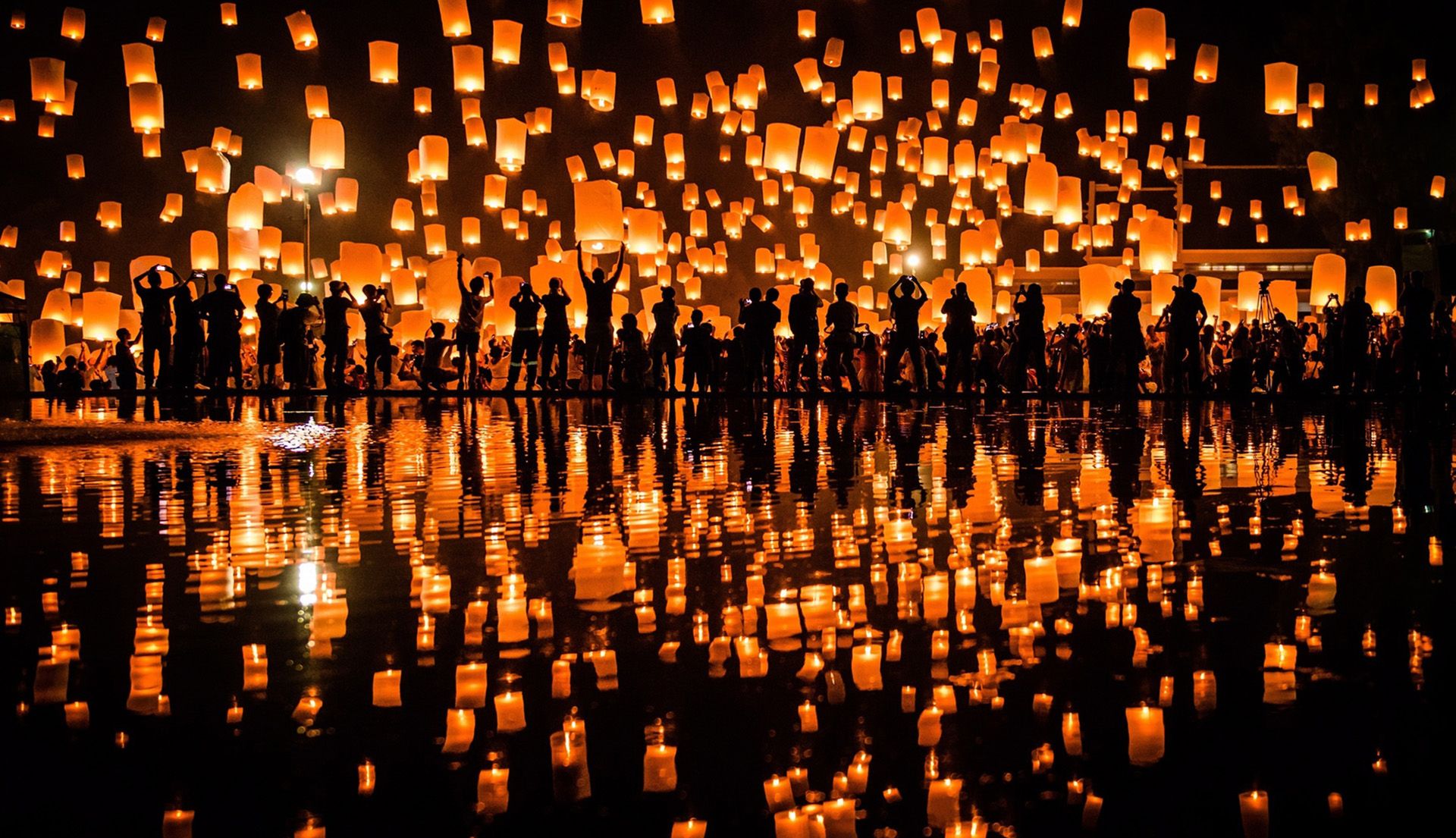 A stunning view of thousands of flying lanterns floating over a lake create a sea of light.  Mirrored in the water the 3,000 lanterns are made from rice paper and bamboo.  Crowds of people pull out cameras and admire the pretty lanterns they have just released into the night sky as part of a magical annual festival.  These photographs were taken by Rodney Ee when he visited the Yi peng Festival in Mae Jo, Thailand.  Please byline: Rodney Ee/Solent News  ? Rodney Ee/Solent News & Photo Agency UK +44 (0) 2380 458800 