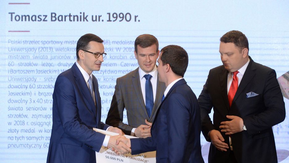 Mateusz Morawiecki przyznaje stypendium Tomaszowi Bartnikowi. Obok minister sportu Witold Bańka i prezes KGHM Marcin Chludzinski