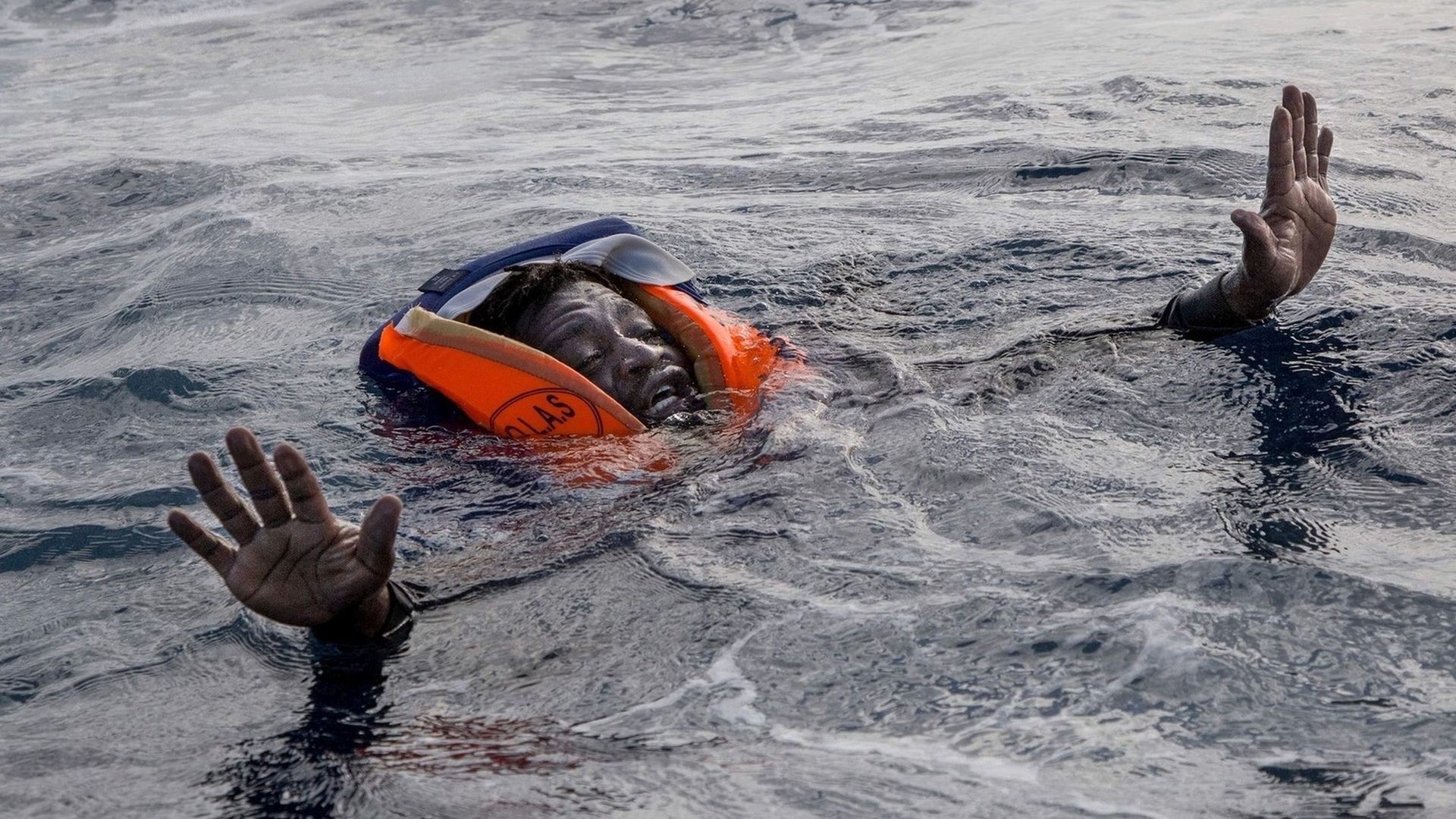 Uratowany imigrant z Afryki w kamizelce ratunkowej