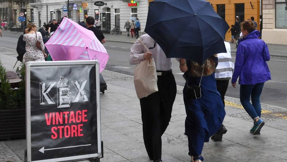 Warszawa. Przechodnie na Nowym Świecie w czasie przechodzącej burzy nad Warszawą