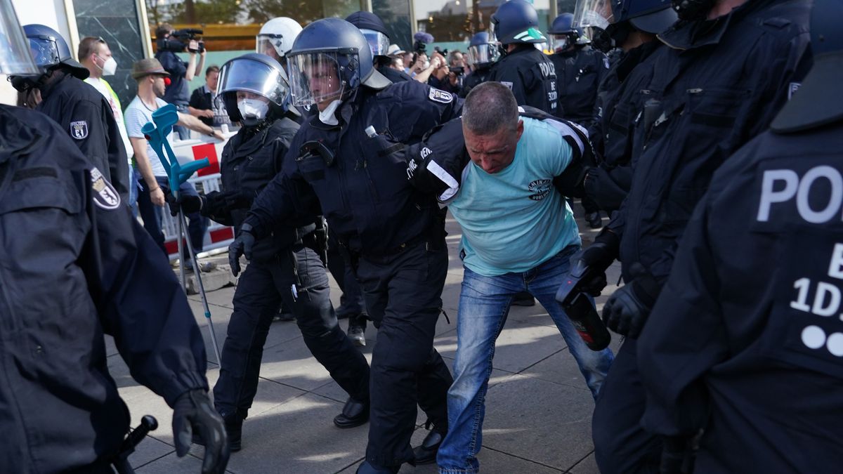Policja zatrzymuje mężczyznę podczas nielegalnego zgromadzenia na Alexanderplatz.
