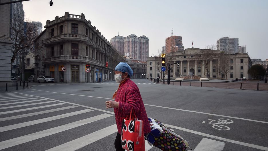 WUHAN, CHINA - FEBRUARY 21 2020: A masked woman walks in the empty street due to the lockdown to curb the COVID epidemic in Wuhan in central China's Hubei province Friday, Feb. 21, 2020.- PHOTOGRAPH BY Feature China / Barcroft Studios / Future Publishing (Photo credit should read Feature China/Barcroft Media via Getty Images)