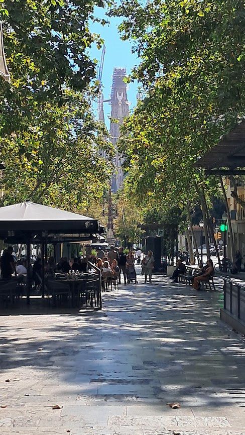 Na końcu alei pełnej kawiarni i restauracji widać Sagrada Famili