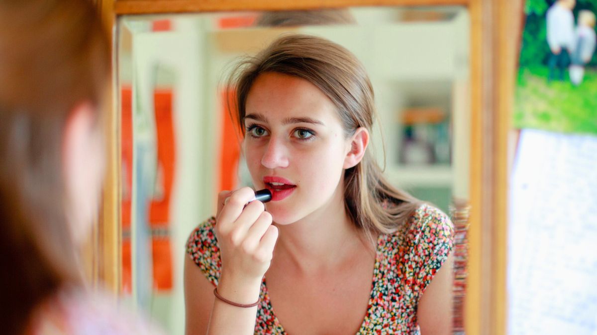 Kobieta maluje usta szminką