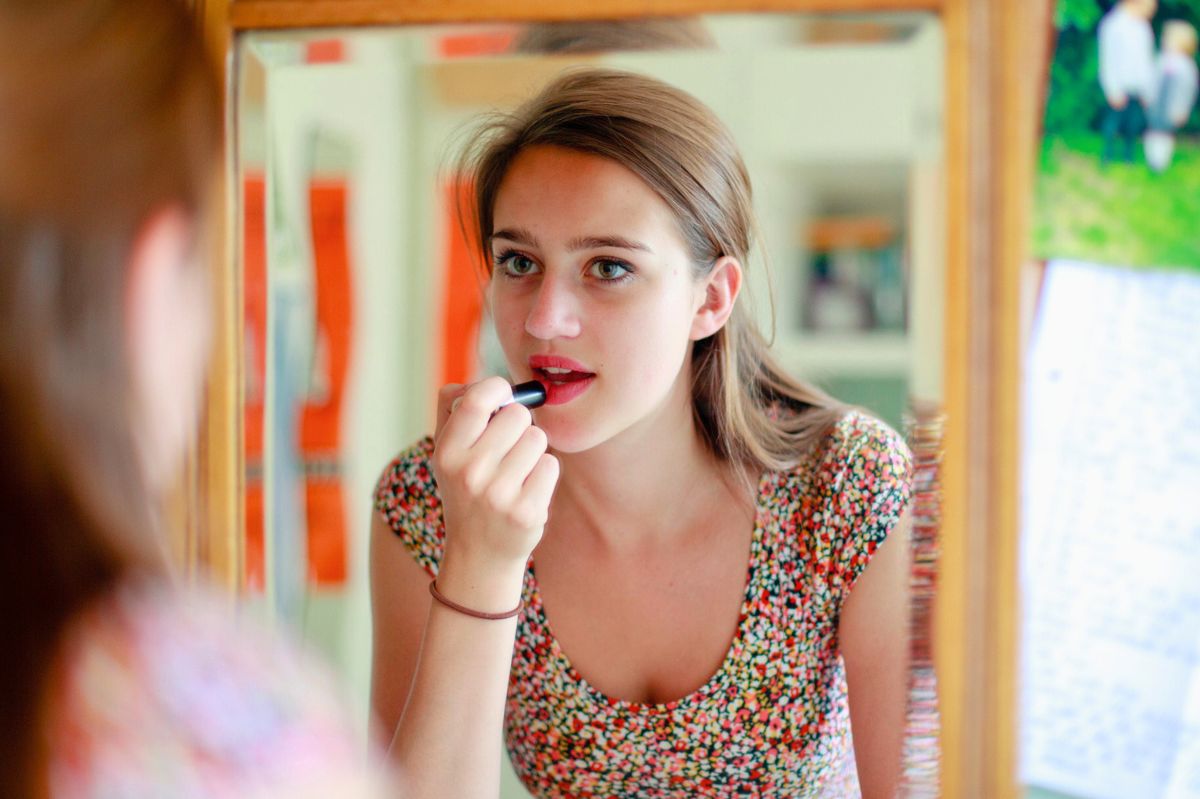 Kobieta maluje usta szminką