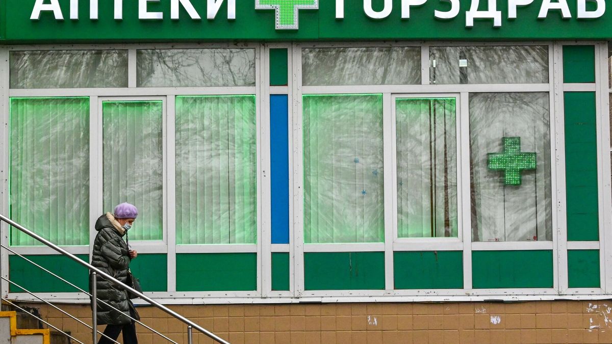 TemporaryA woman wearing a face mask leaves a pharmacy in the town of Podolsk some 40 kilometres outside Moscow on November 12, 2021. (Photo by Yuri KADOBNOV / AFP)YURI KADOBNOV