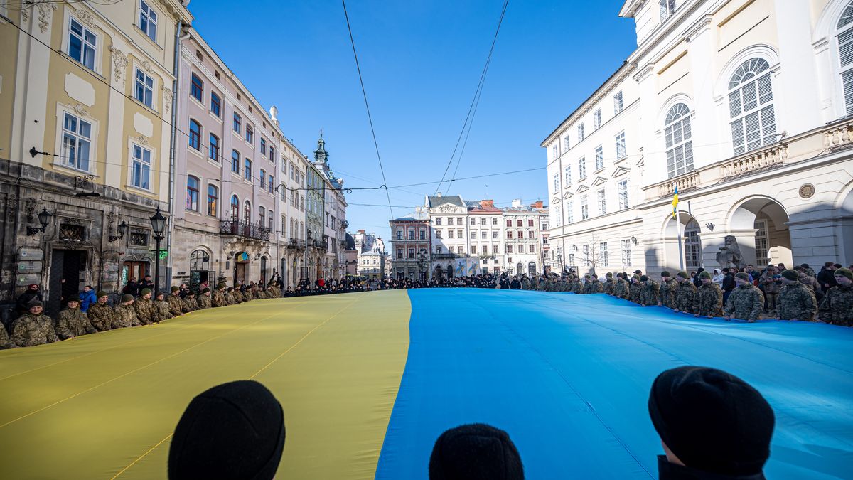 LVIV, UKRAINE - MARCH 10: Ukrainian servicemen and police officers hold an unfurled 17-meter flag of Ukraine on Rynok Square on March 10, 2023 in Lviv, Ukraine. On March 10, 1865, a concert dedicated to the memory of the Ukrainian writer Taras Shevchenko was held in Przemyśl. The final concert performance was the performing of the State Anthem of Ukraine "Shche ne vmerla Ukrainy i slava, i volia" (The glory and freedom of Ukraine has not yet perished). On March 10, 2023, representatives of the authorities, military personnel, police officers, residents and guests of the city gathered at Rynok Square in Lviv to sing the State Anthem of Ukraine together. Military personnel and police officers unfurled the 17-meter Ukrainian flag as another integral attribute of Independence. (Photo by Stanislav Ivanov/Global Images Ukraine via Getty Images)