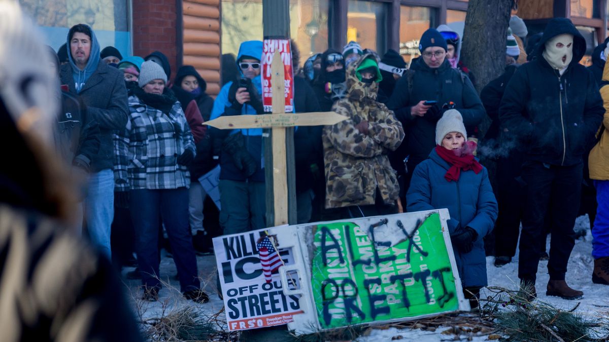 Residents next to a sign and cross near the scene of a shooting by a federal law enforcement agent in Minneapolis, Minnesota, US, on Sunday, Jan. 25, 2026. A Border Patrol agent shot and killed a man believed to be a US citizen in Minneapolis on Saturday, the latest violent incident by law enforcement that has sparked widespread protests and condemnations by state and local officials. Photographer: Jaida Grey Eagle/Bloomberg via Getty Images