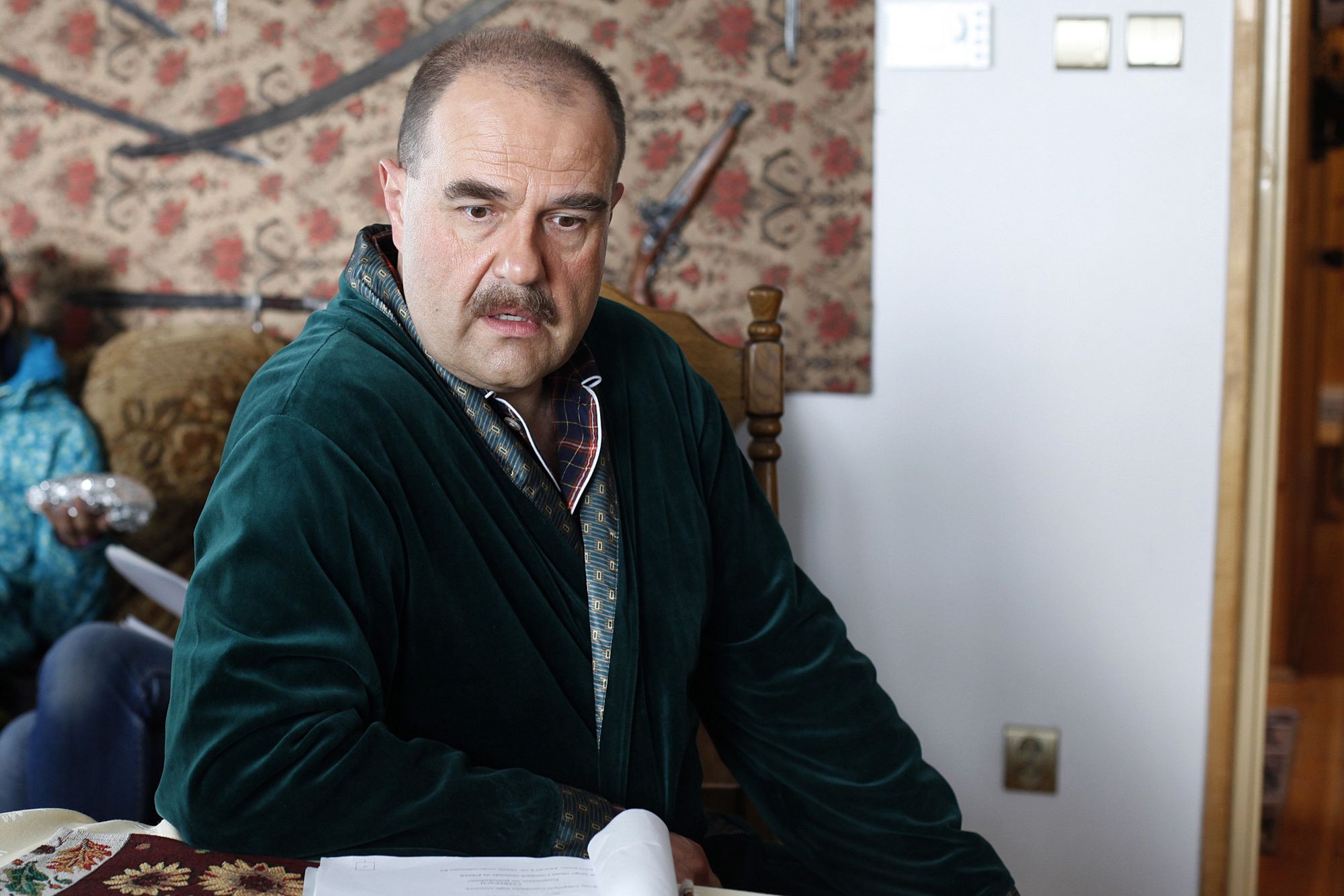 "Ranczo", wójt na tle zabytkowej broni