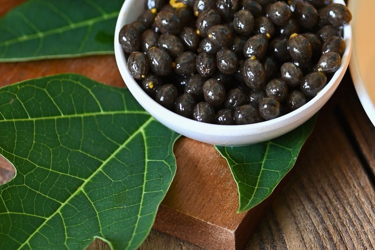 Papaya seeds in a white bowl