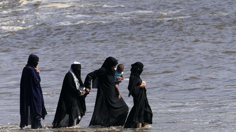 Grupa muzułmańskich kobiet ochładza się na wybrzeżu Morza Arabskiego 