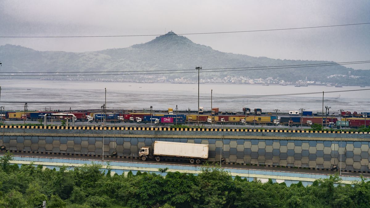 A train transporting shipping containers travels along a track near the Jawaharlal Nehru Port in Navi Mumbai, Maharashtra, India, on Saturday, Aug. 9, 2025. US President Donald Trump said he'd impose a 50% tariff on Indian exports to the US  half of which includes a penalty for purchases of Russian oil. Photographer: Abeer Khan/Bloomberg via Getty Images