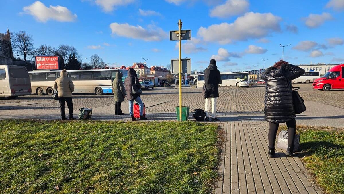 Pasażerowie oczekujący na przyjazd busa na placu przy al. Tysiąclecia / ul. Cerkiewna