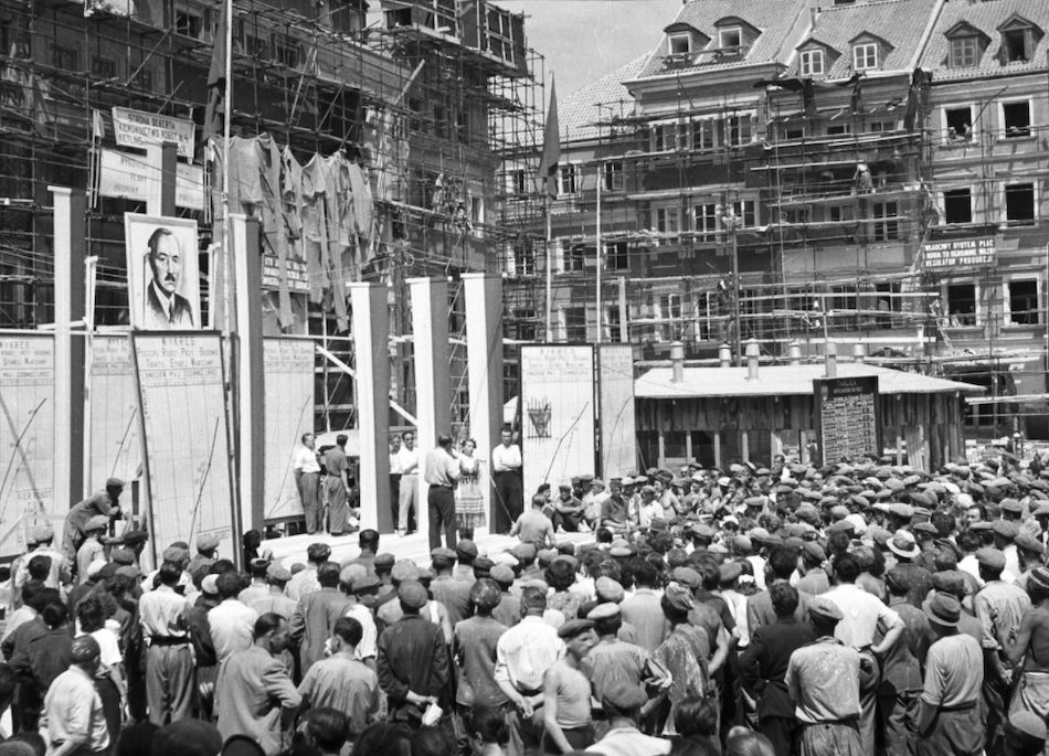 Warszawa. Rok 1953, chwilę przed zdjęciem rusztowań wokół odbudowanych kamienic Starówki. 22 lipca, również wokół portretu Bieruta, staną zaproszeni na uroczystość otwarcia zrekonstruowanego Rynku budowniczowie i mieszkańcy stolicy