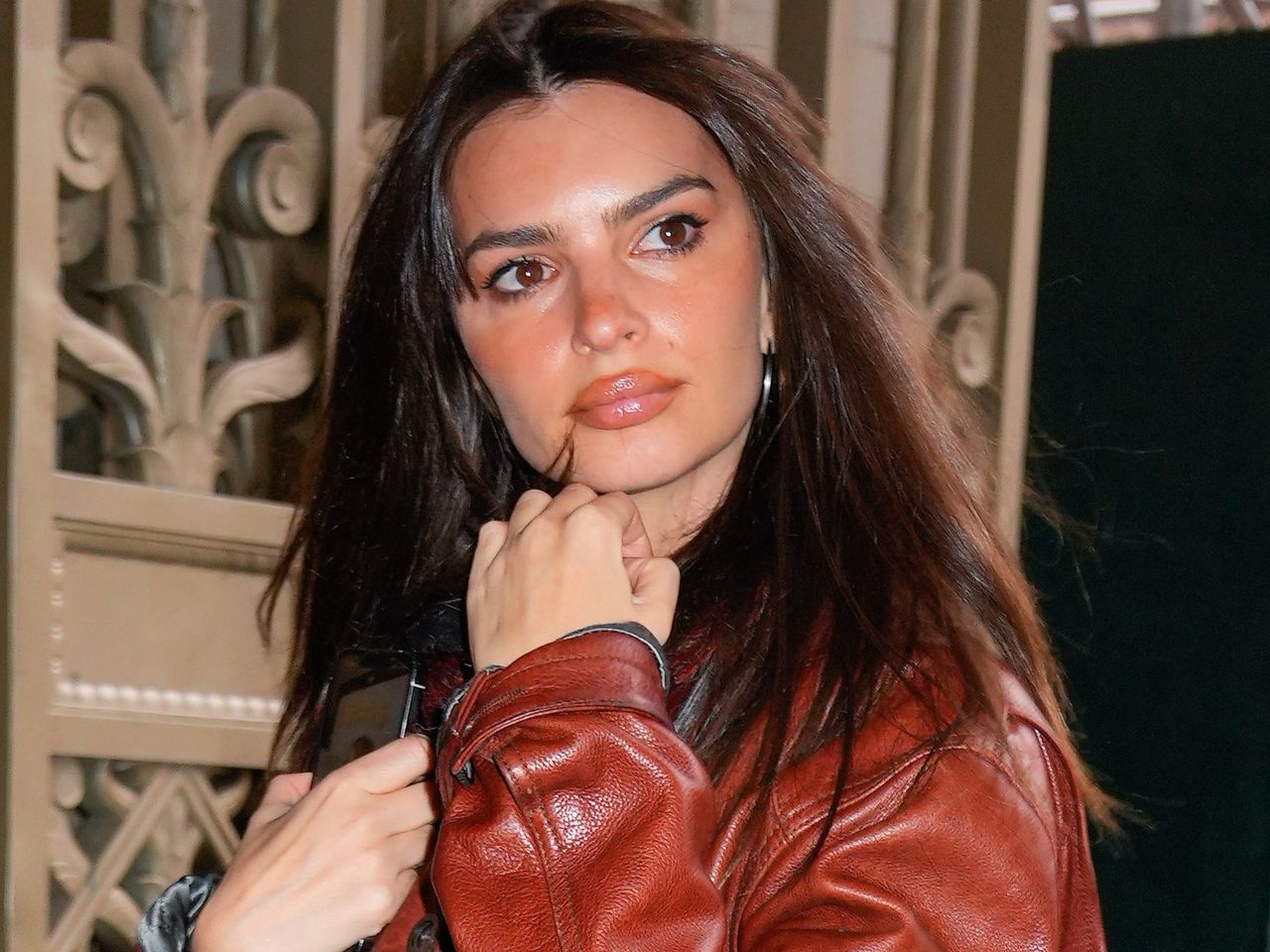 Emily Ratajkowski w kusym mundurku. Jednak uwagę skupia coś innego