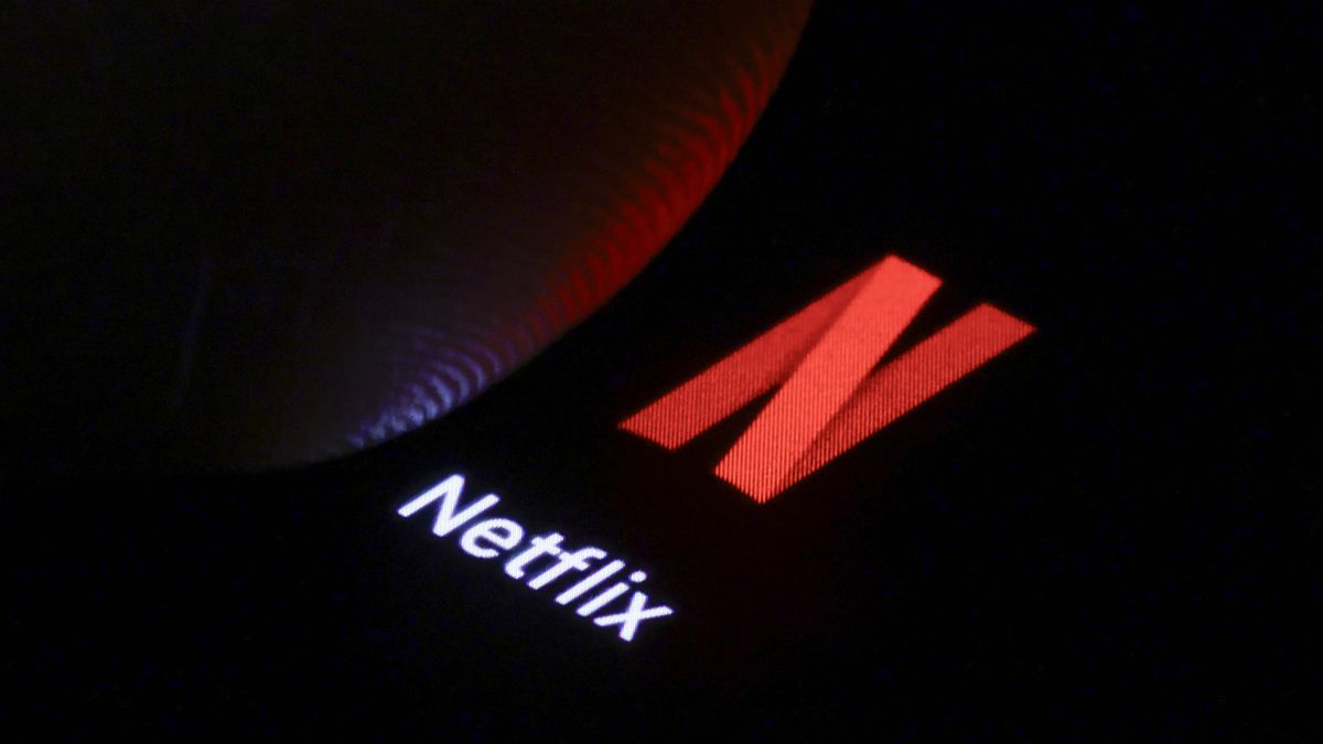 BERLIN, GERMANY - JANUARY 03: In this photo illustration the logo of Netflix can be seen next to a finger on a smartphone on January 03, 2025 in Berlin, Germany. (Photo Illustration by Thomas Trutschel/Photothek via Getty Images)