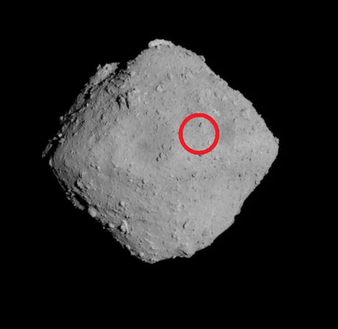 Asteroida Ryugu. Na czerwono zaznaczono miejsce, z którego Hayabusa 2 pobrała próbki do badań.