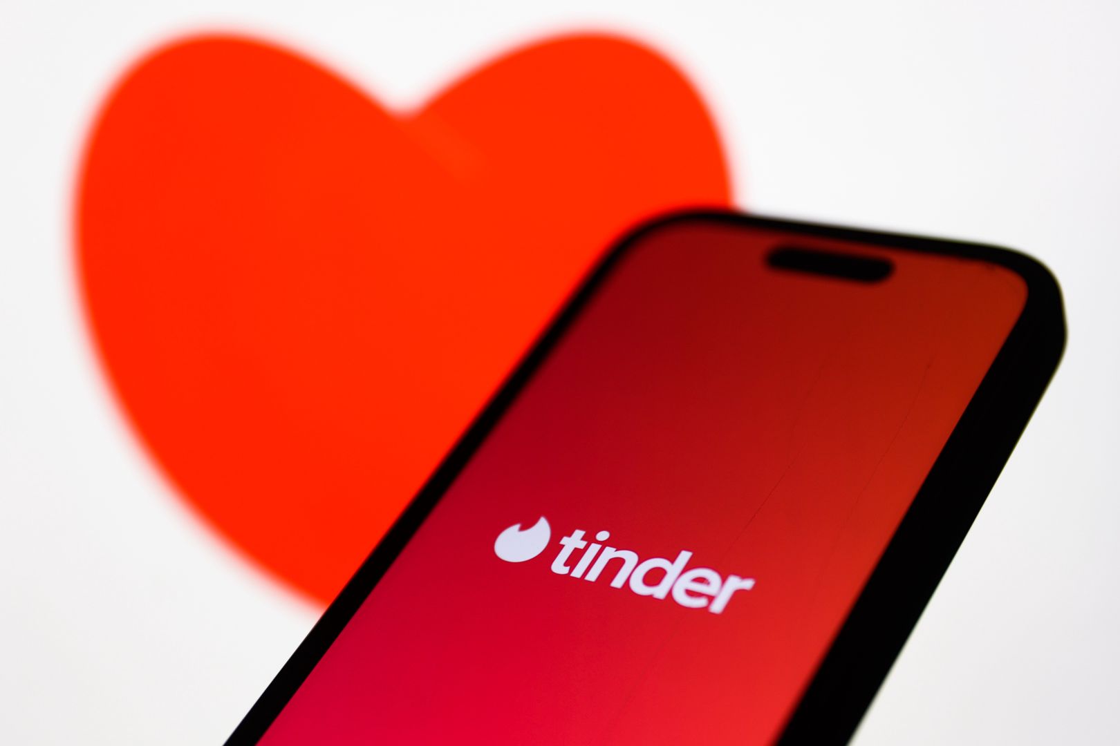 An image of heart displayed on a laptop screen and Tinder logo displayed on a phone screen are seen in this illustration photo taken in Krakow, Poland on February 21, 2024. (Photo by Jakub Porzycki/NurPhoto via Getty Images)