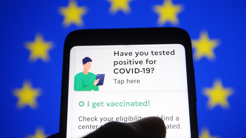 UKRAINE - 2021/04/21: In this photo illustration a TousAntiCovid app is seen on a smartphone with the EU flag in the background.France will reportedly be the first European Union member state to introduce the COVID-19 travel pass, the first example of a Digital Green Certificate that is slated to be rolled out across the EU by mid-June, reportedly by media. The TousAntiCovid app has already been downloaded by about 15 million people. It will display PCR tests and antigen tests. It will also include vaccination certificates. The COVID passports will be available as a mobile app or in paper form. (Photo Illustration by Pavlo Gonchar/SOPA Images/LightRocket via Getty Images)