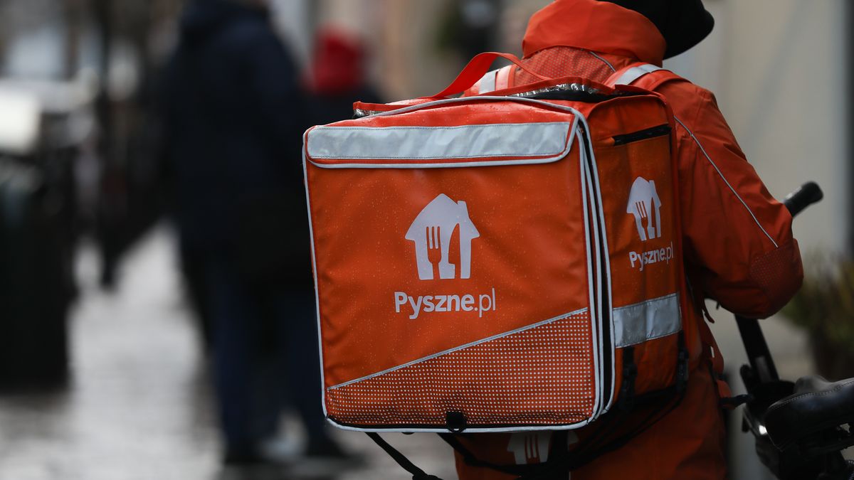 A courier from Pyszne.pl on a bike is seen on the street in Krakow, Poland, on November 18, 2024. (Photo by Klaudia Radecka/NurPhoto via Getty Images)