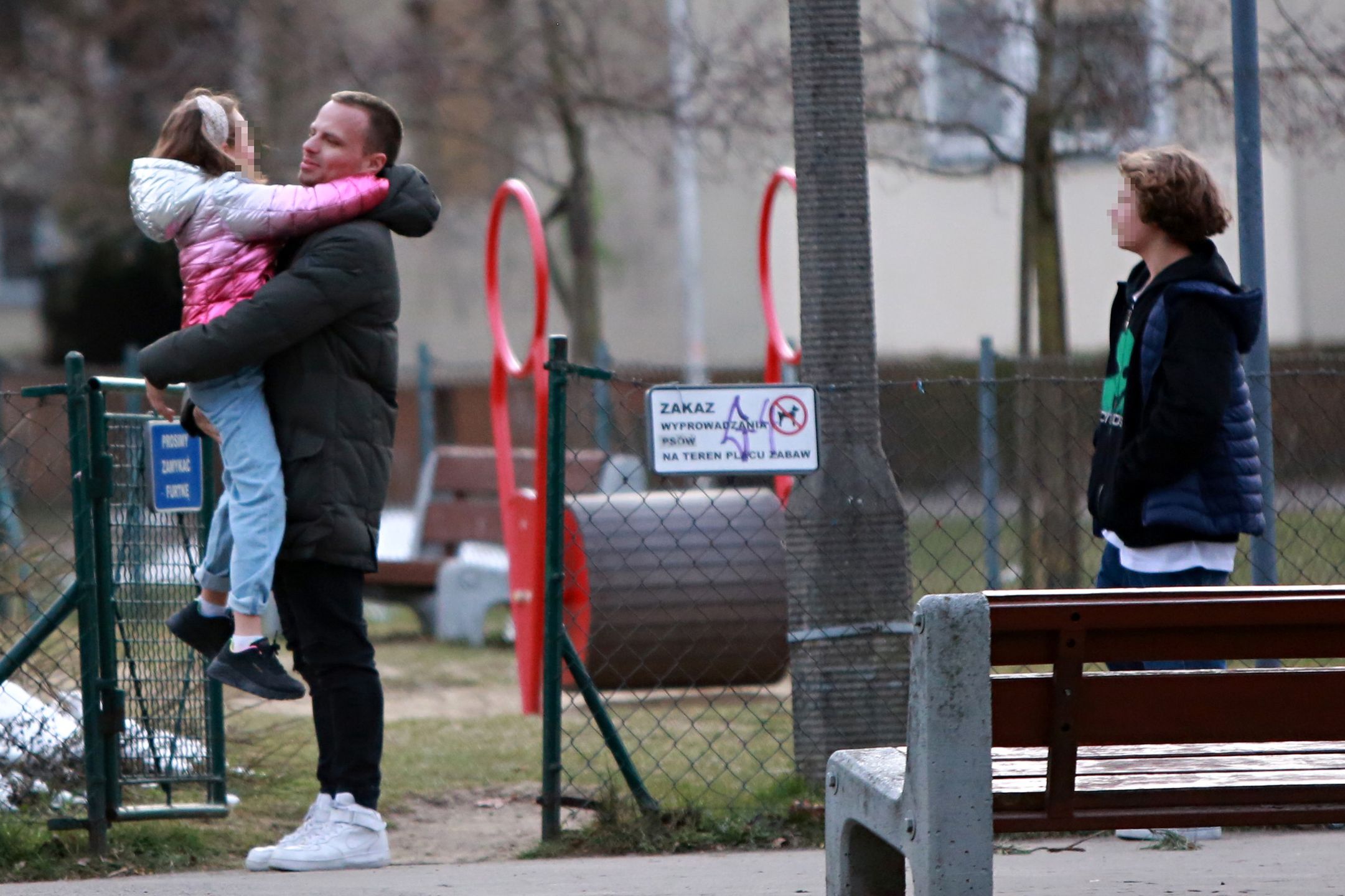 Marcin Hakiel dokazuje z dziećmi na placu zabaw