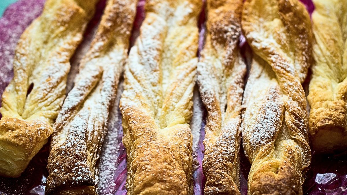 Faworki z ciasta francuskiego posypane cukrem pudrem