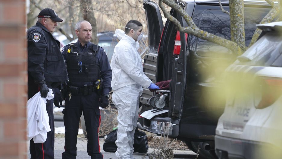 Członek biura koronera przenosi nosze na miejsce zabójstwa, w którym w czwartek, 7 marca 2024 r. znaleziono zwłoki sześciu osób na przedmieściach Barrhaven w Ottawie. 