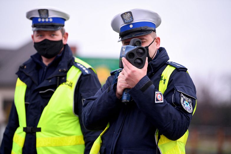 policyjna kontrolaDuńkowiczki, 01.01.2022. Patrol policji podczas kontroli na drodze krajowej numer 77 w Duńkowiczkach, 1 bm. 1 stycznia br. zaczęły obowiązywać zaostrzone przepisy ruchu drogowego podnoszące m.in. stawki mandatów karnych. (dd/awol) PAP/Darek DelmanowiczDarek Delmanowiczdrogówka, ilustracja, kontrola, mandat, mandaty, nowe, nowe stawki mandatów, nowelizacja Prawa o ruchu drogowym, nowy taryfikator, policja, policjanci, policjant, przepisy, ruch drogowy, surowe, wykroczenia, wykroczenie, zaostrzone, radar, radarowa, kamizelka, napis, odblaskowa, służbowa, covid, covid-19, czwarta fala, epidemia, epidemie i zarazy, koronawirus w Polsce, maseczka ochronna, maska, pandemia, SARS-CoV-2, stan epidemii, wirus