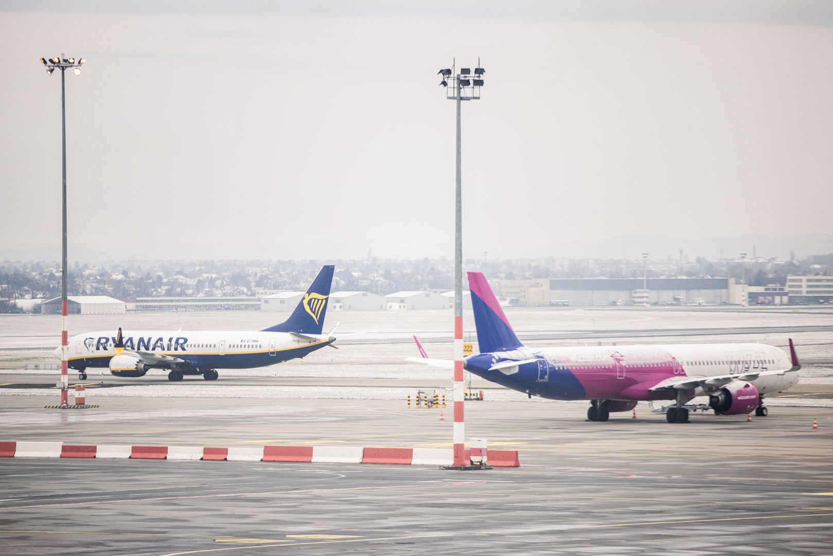 Passenger aircraft, operated by Ryanair Holdings Plc, left, and Wizz Air Holdings Plc, on the tarmac at Budapest Ferenc Liszt International Airport in Budapest, Hungary, on Monday, Jan. 8, 2024. Hungary is looking to attract the Qatar Investment Authority to a consortium the government is forming for the purchase of Budapest Airport. Photographer: Akos Stiller/Bloomberg via Getty Images