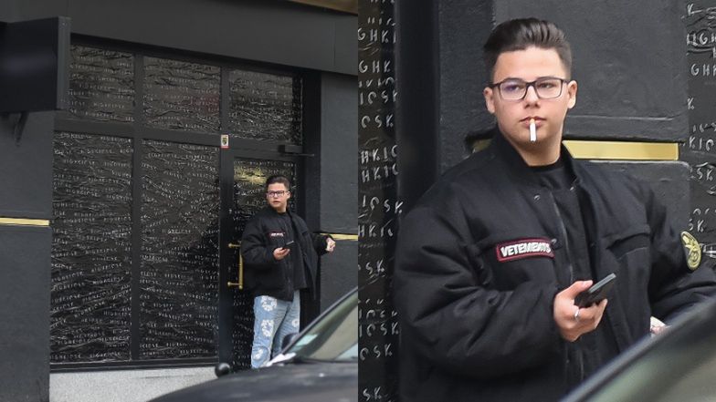 Allan Krupa pali papierosa przed butikiem