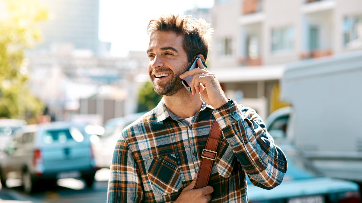 Facet rozmawia przez telefon na ulicy.
