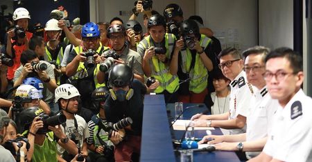 Fotoreporterzy w maskach i kamizelkach protestują przeciwko policji w Hongkongu
