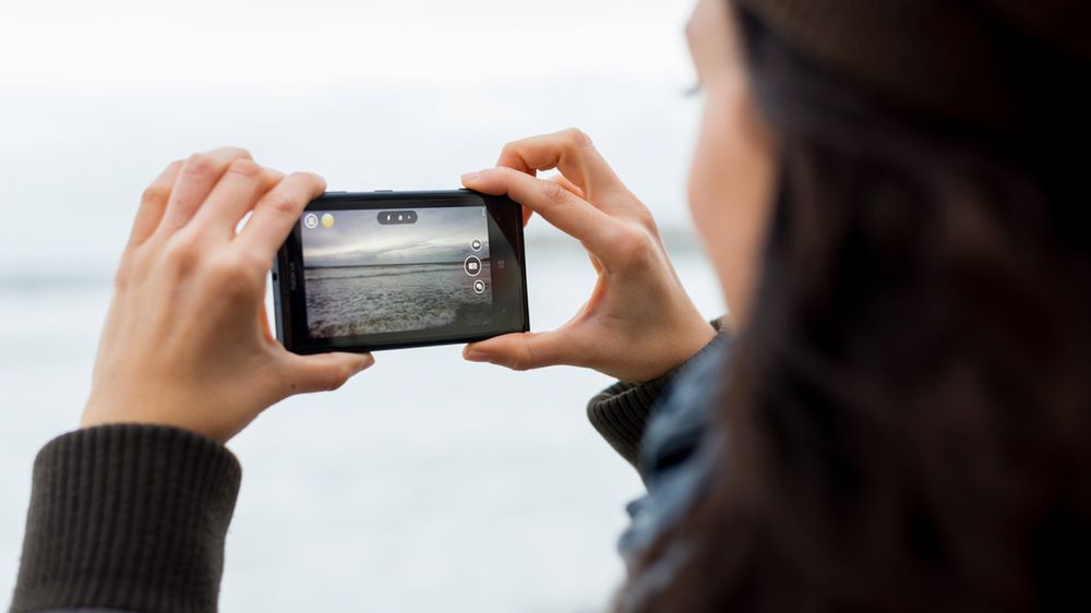 Kobieta wykonująca zdjęcie Nokią Lumią 1020 z depositphotos
