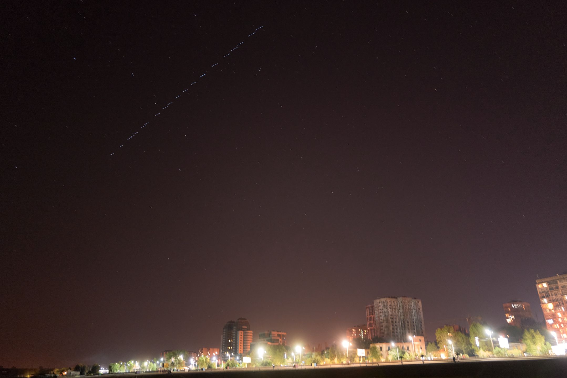ZAPORIZHZHIA, UKRAINE - SEPTEMBER 14: A constellation of Elon Musk's SpaceX Starlink satellites fly above Zaporizhzhia as local residents fish at night on the Dnipro River on September 14, 2023 in Zaporizhzhia, Ukraine. (Photo by Pierre Crom/Getty Images)