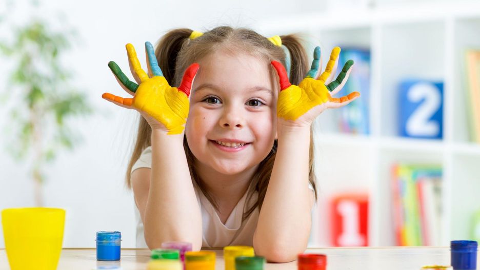 Dziewczynka maluje palcami. 