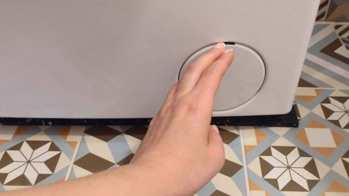 Kobieta chce awaryjnie otworzyć drzwi pralki