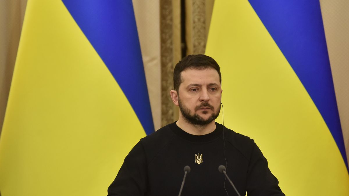 Na zdjęciu Wołodymyr Zełenski w trakcie konferencji prasowej na tle ukraińskich flag