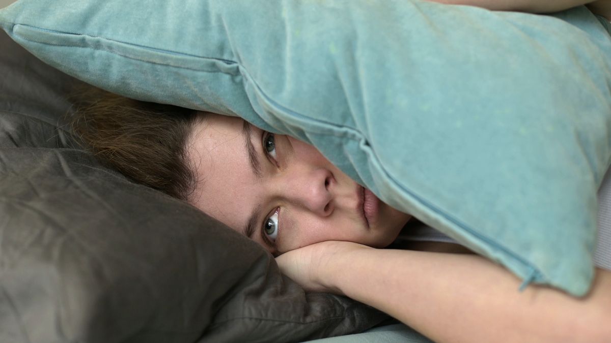 woman covers her ears with pillows so as not to hear the noise
Young woman covers her ears with pillows so as not to hear the noise that interferes with her sleep
Vyacheslav Dumchev
